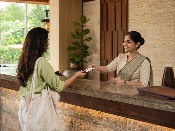 Hotel receptionist assisting a guest at the front desk